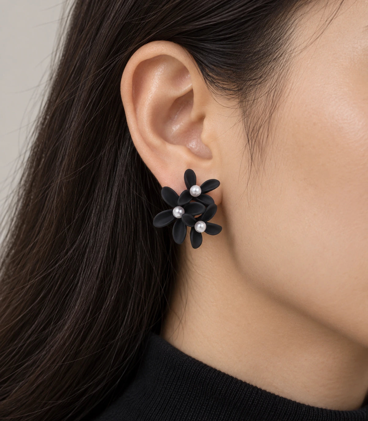 JIMIKI Black cascading floral cluster stud earrings, worn on the ear with the floral cluster visible #color_black