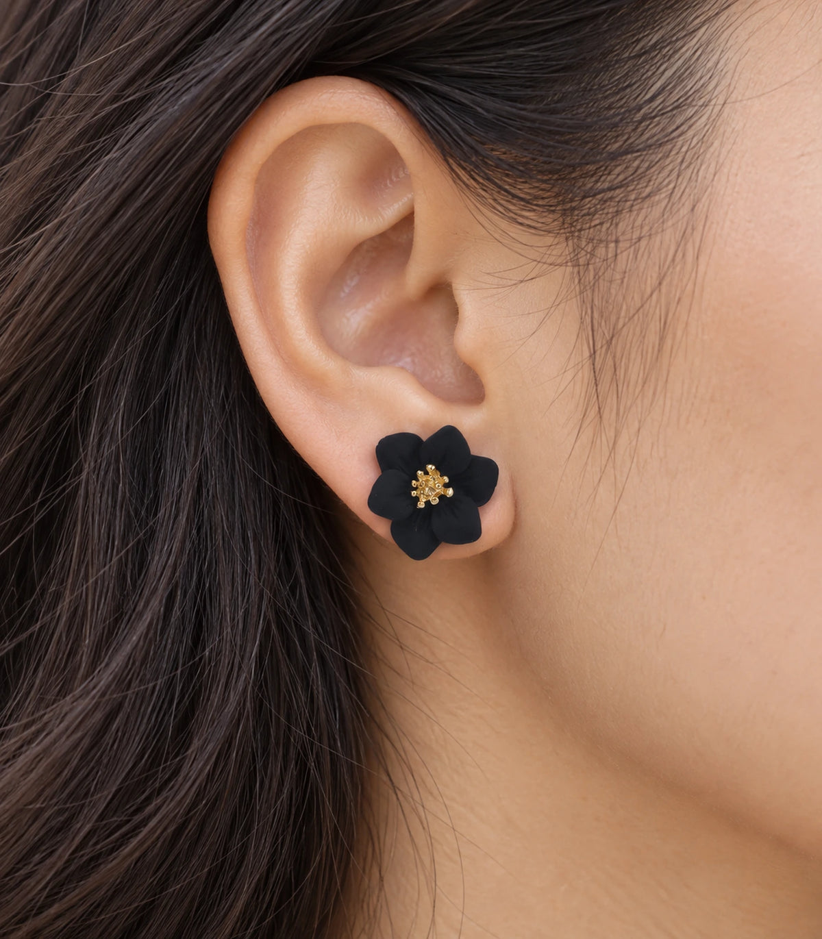 JIMIKI Black compact six petal flower stud earrings, close-up of six rounded petals and gold-tone centre #color_black