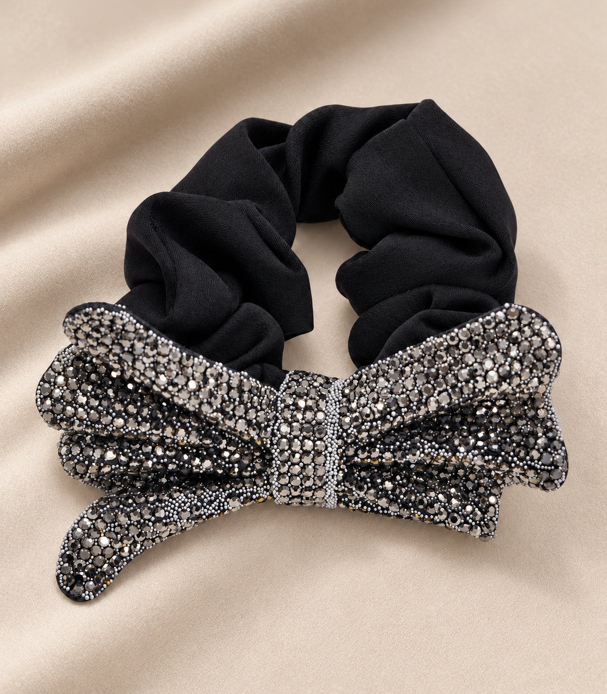 Complete black scrunchie with crystal-like layered bow in a fabric flatlay