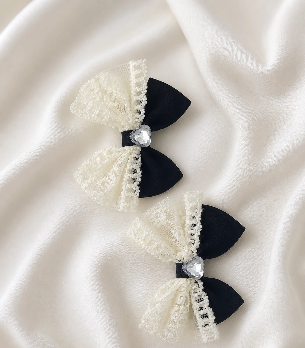Editorial flat lay of the Black Ivory Lace Heart Bow Clip Pair