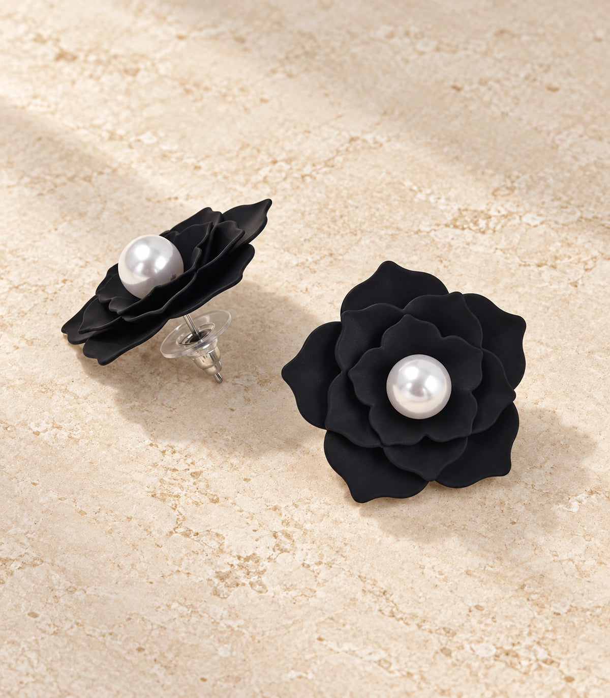 JIMIKI Layered Flower Pearl Stud Earrings, Black — pair in a styled flat lay #color_black