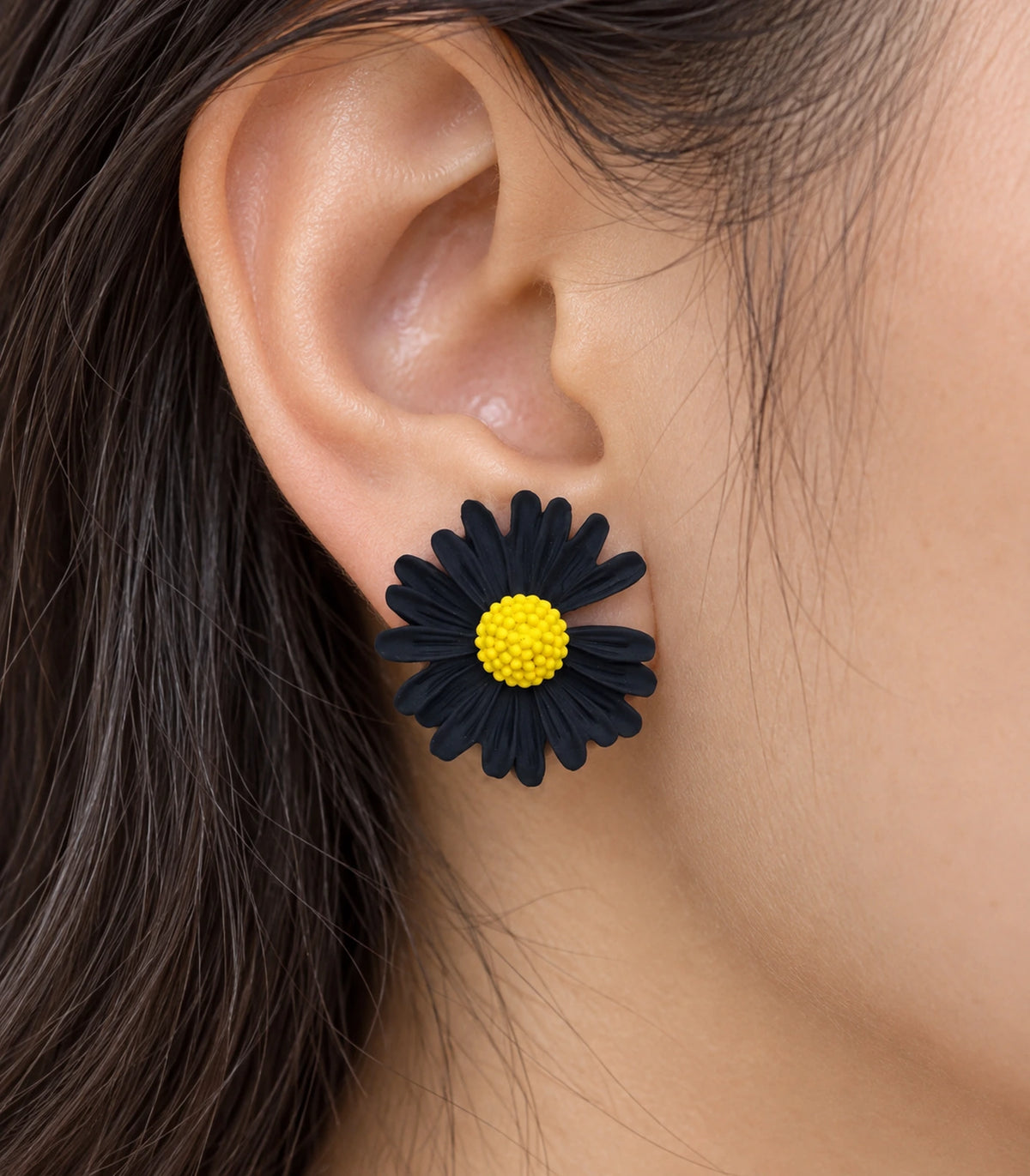 JIMIKI Black yellow centre daisy stud earrings, close-up of grooved petals and yellow centre #color_black