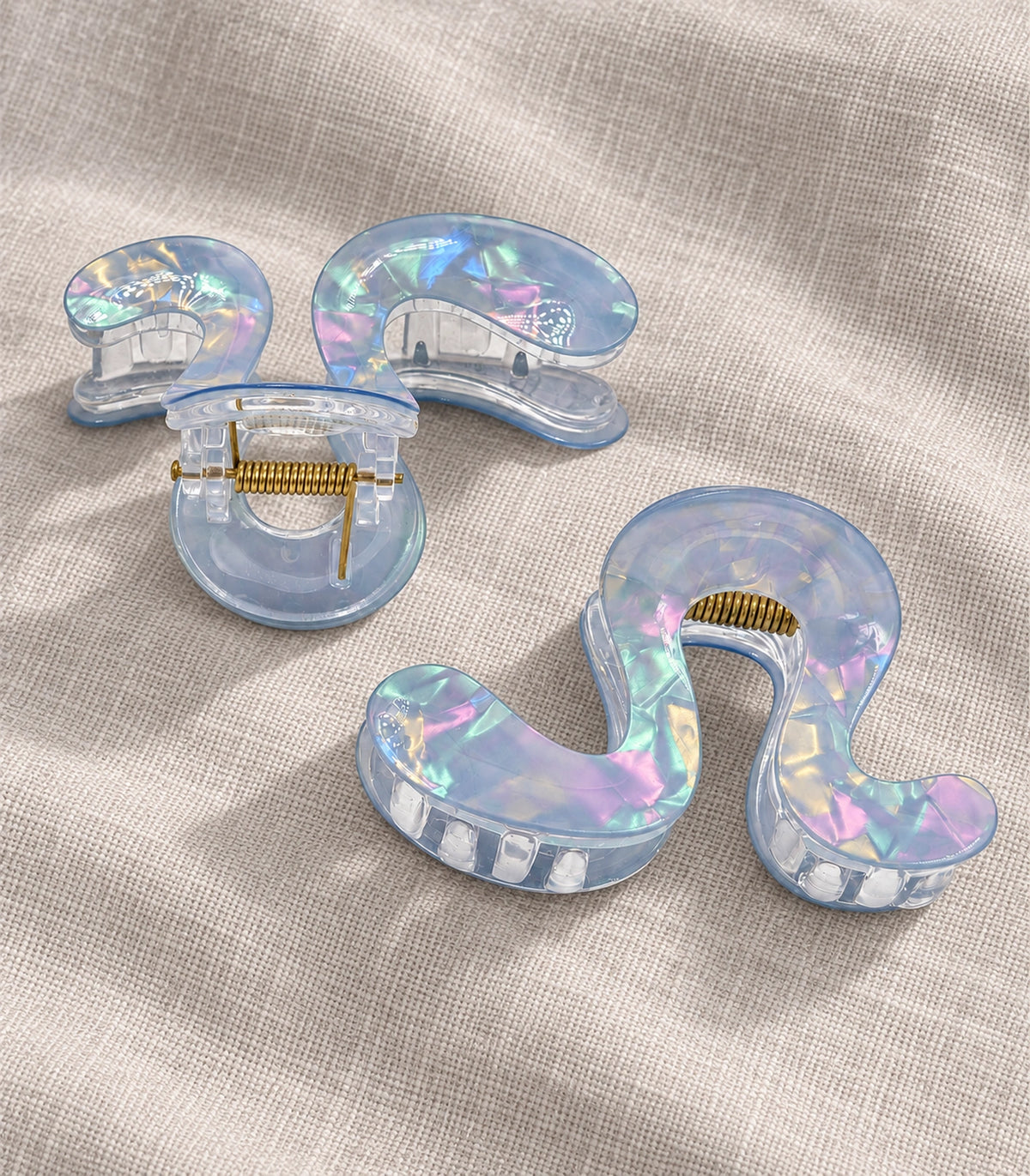 JIMIKI Iridescent S Shaped Hair Claw Clips in Blue, editorial flat lay #color_blue
