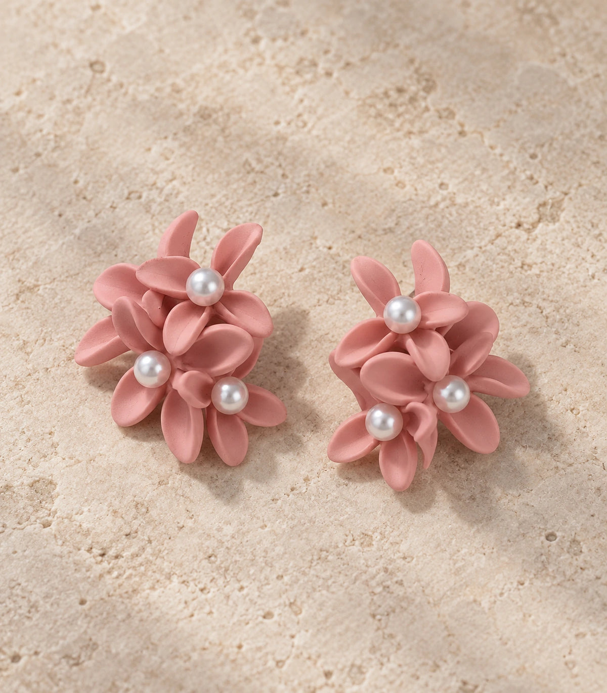 JIMIKI Blush Pink cascading floral cluster stud earrings, matching pair styled on a light textured surface #color_blush pink