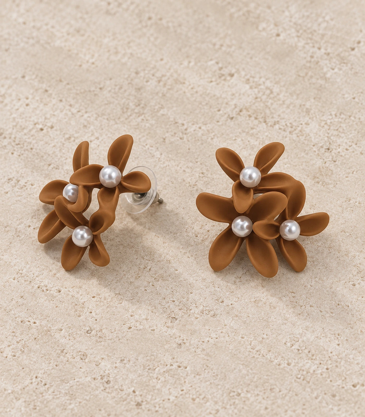 JIMIKI Camel cascading floral cluster stud earrings, matching pair styled on a light textured surface #color_camel
