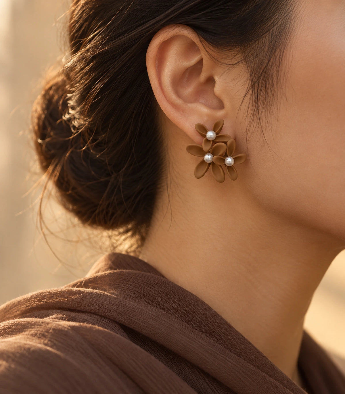 JIMIKI Camel cascading floral cluster stud earrings, worn with softly lit editorial styling #color_camel