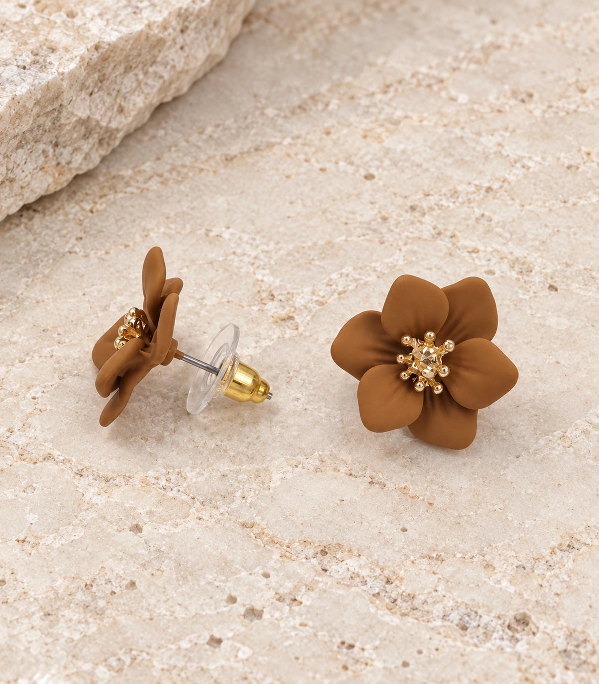 JIMIKI Camel compact six petal flower stud earrings, matching pair in a styled flat lay #color_camel