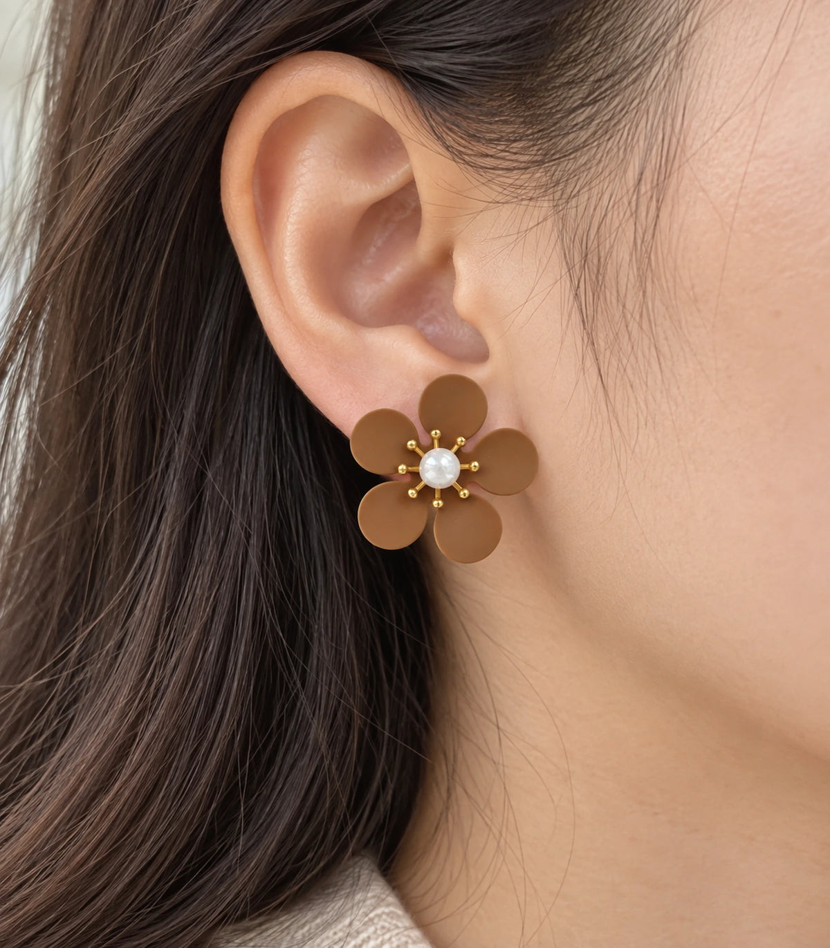 JIMIKI camel five-petal flower stud earrings with pearl-effect centre, closeup of flower stud in a natural worn setting #color_camel