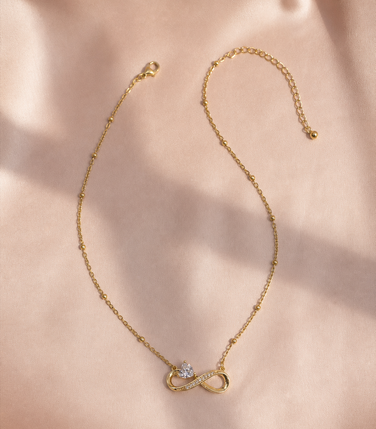 Crystal Infinity Heart Necklace in an editorial flat lay