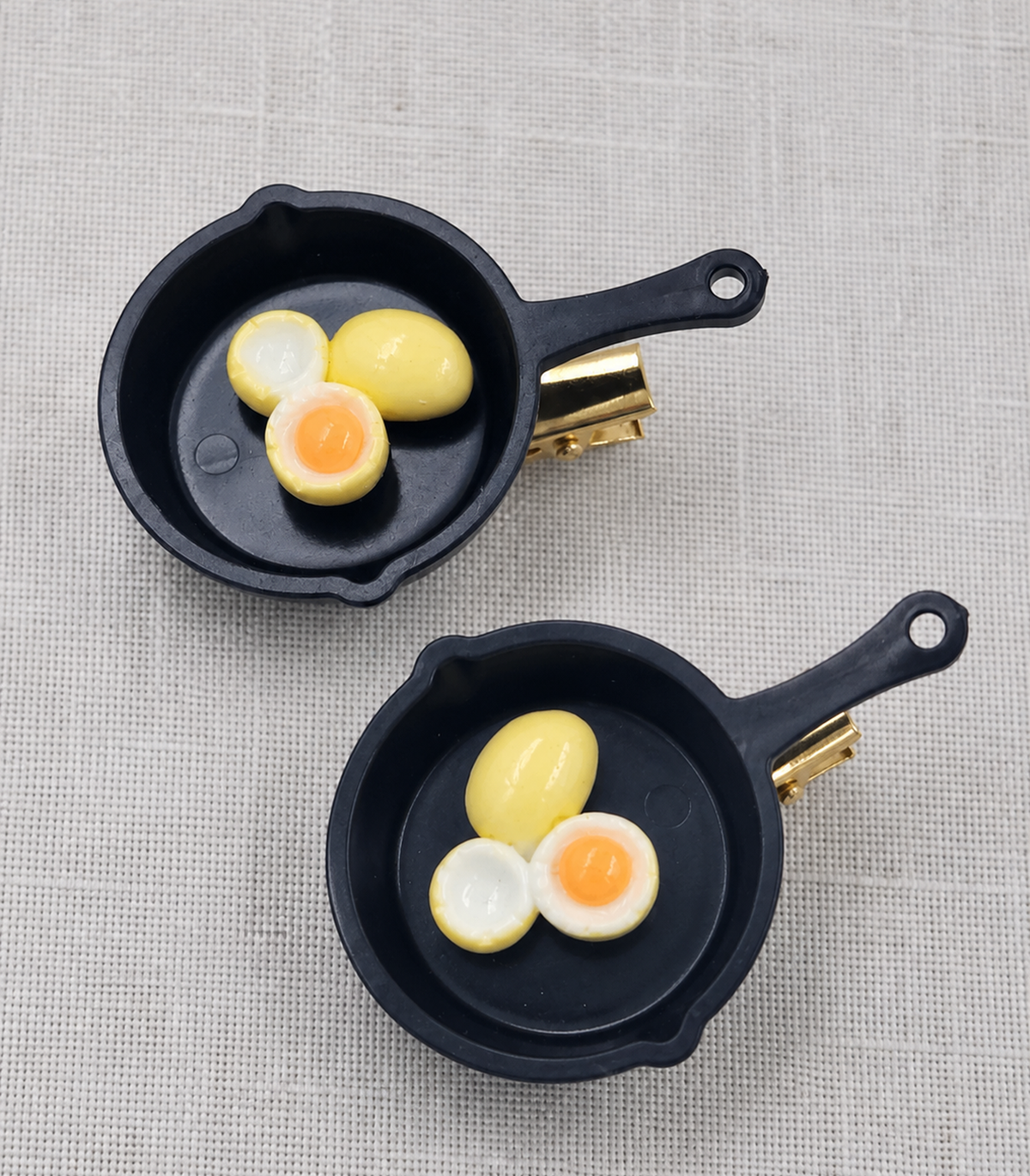 JIMIKI Egg Trio Frying Pan Barrette Pair in Black / Cream / Orange, close-up detail