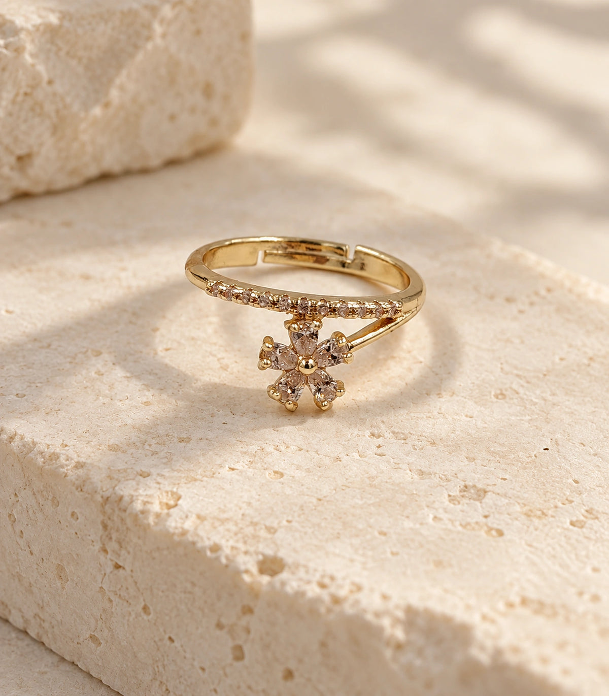 Gold Champagne Crystal Flower Sweep Ring — complete ring on a pale stone plinth