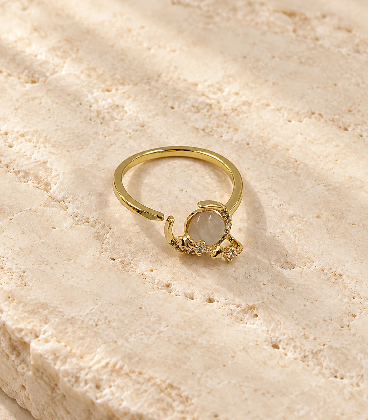 Gold crescent star cabochon open ring — editorial flatlay