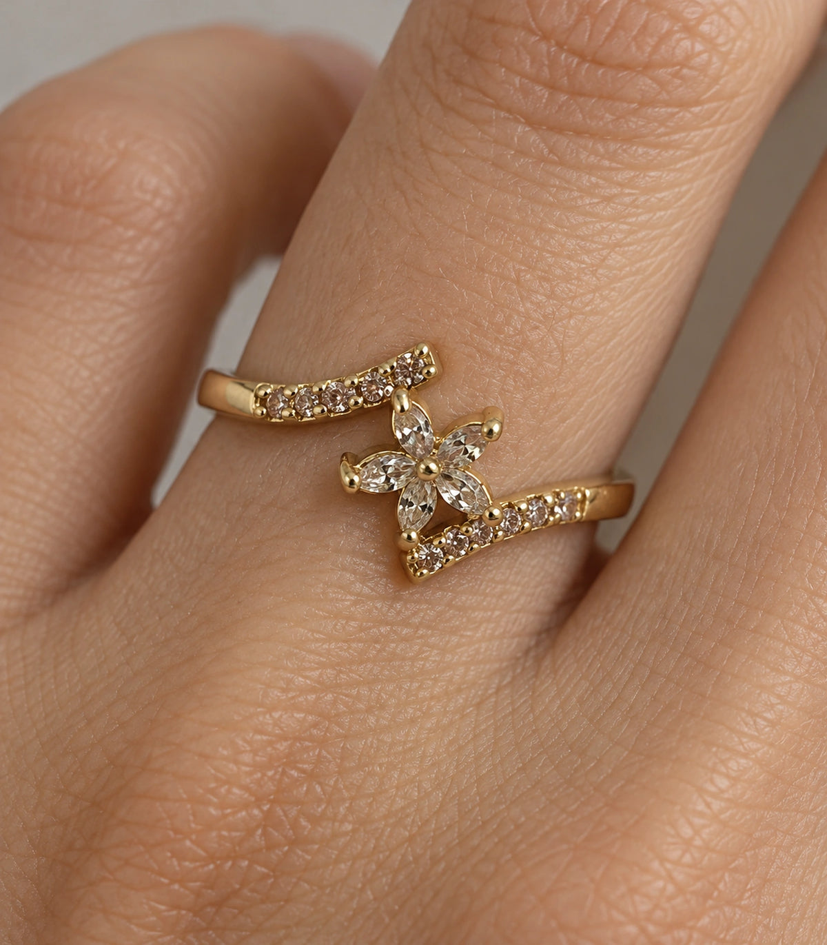 Close view of the gold-tone ring and clear accents worn on a finger