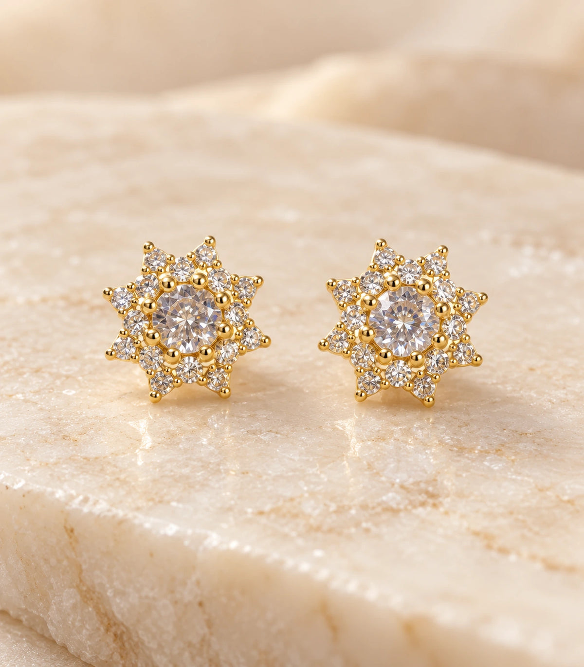 Detailed front view of the matching gold-tone crystal sunburst stud earrings