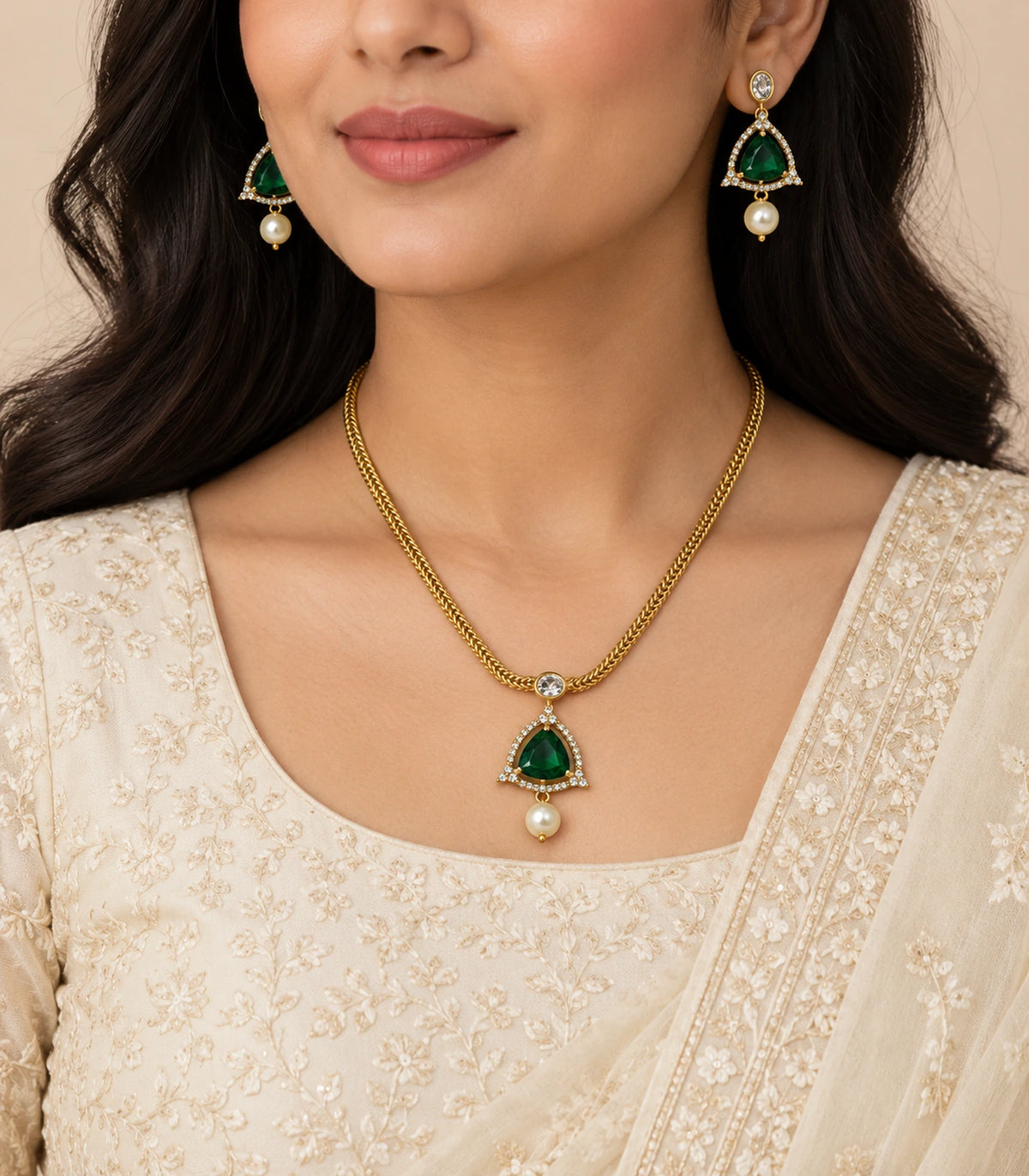 Gold emerald-green necklace set worn with an ivory outfit