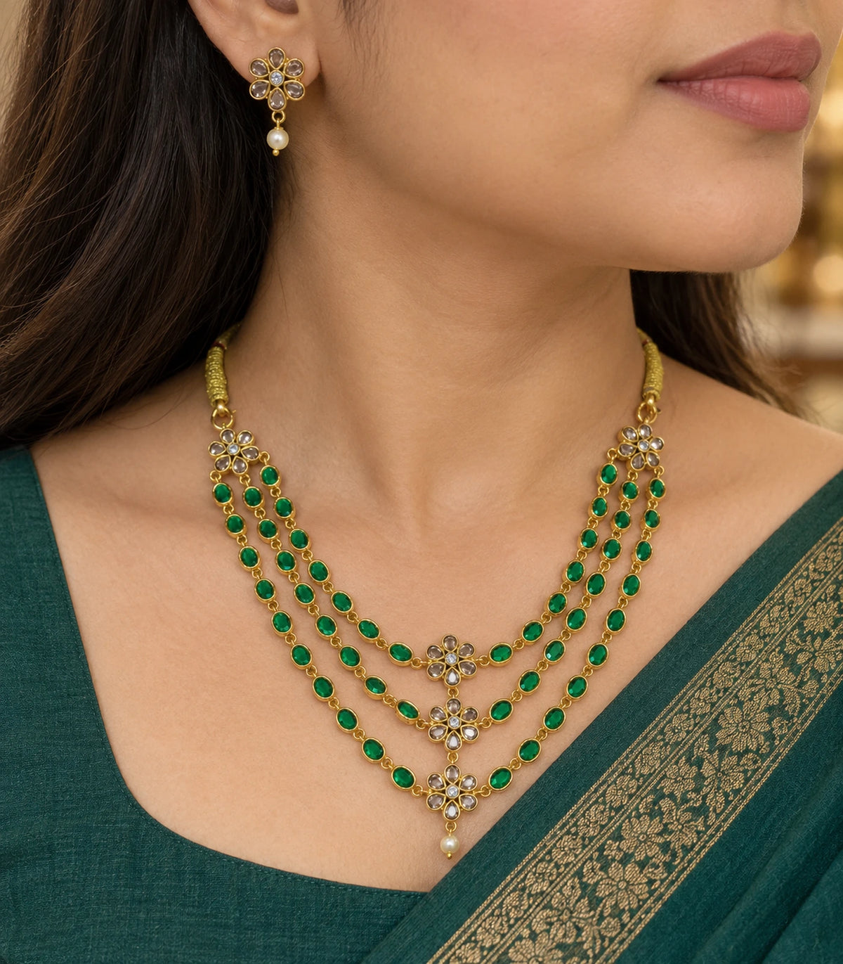 Close view of the green oval-link necklace, clear floral centres and matching white-drop earring worn with green clothing