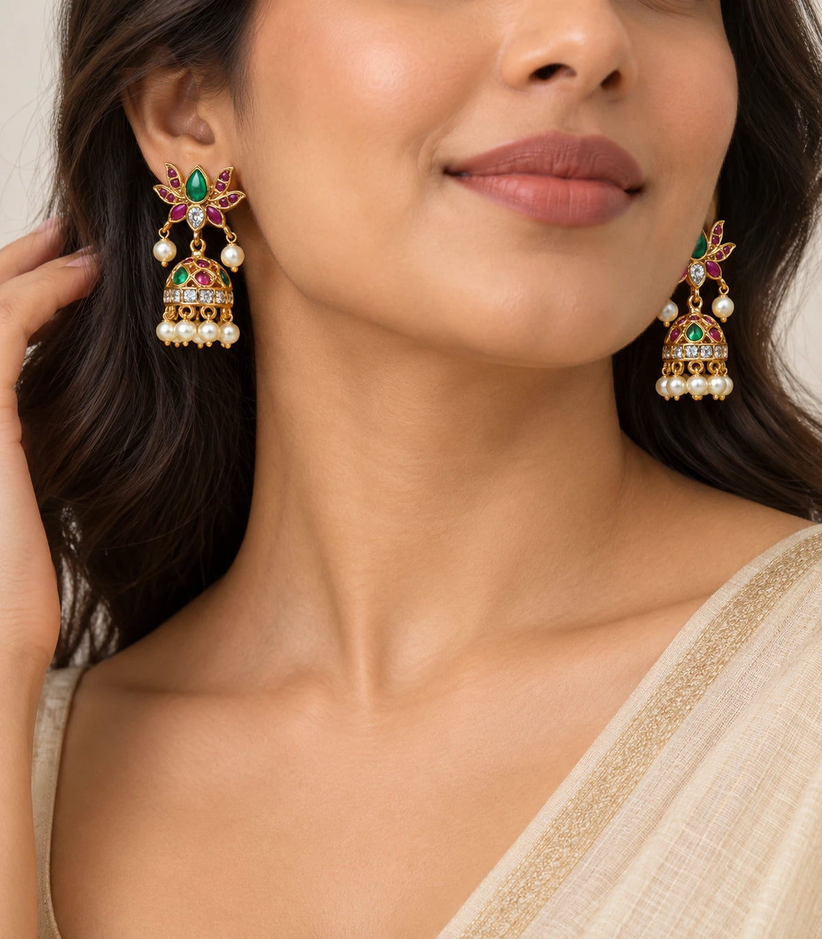 Gold green and magenta lotus jhumka earrings worn beside the face