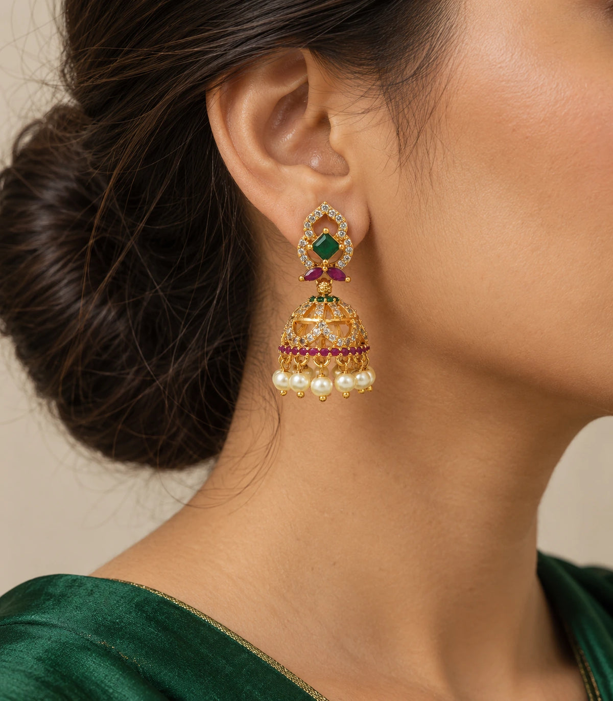 Gold-tone green and magenta pearl-style jhumka earring worn with a green outfit