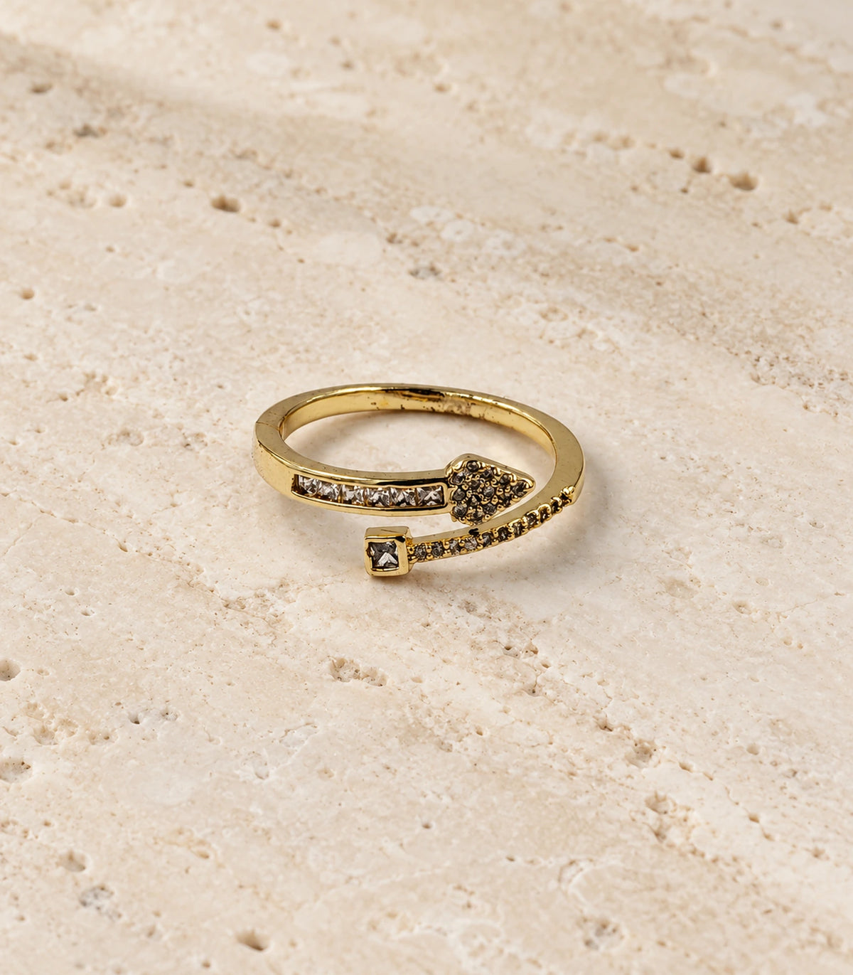 Complete gold heart and square wrap ring on a textured stone surface