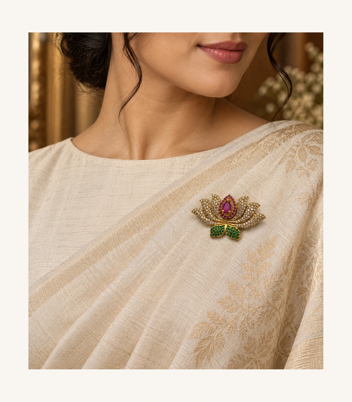 Magenta lotus brooch styled with a cream sari in an editorial portrait