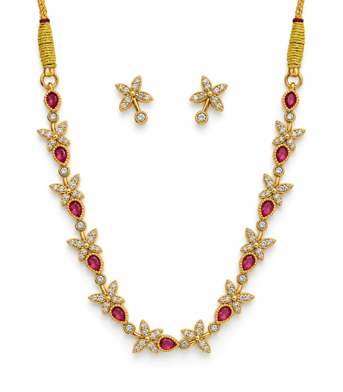 Gold-tone necklace with alternating magenta teardrops and clear four-leaf clusters, with matching clear earrings on white