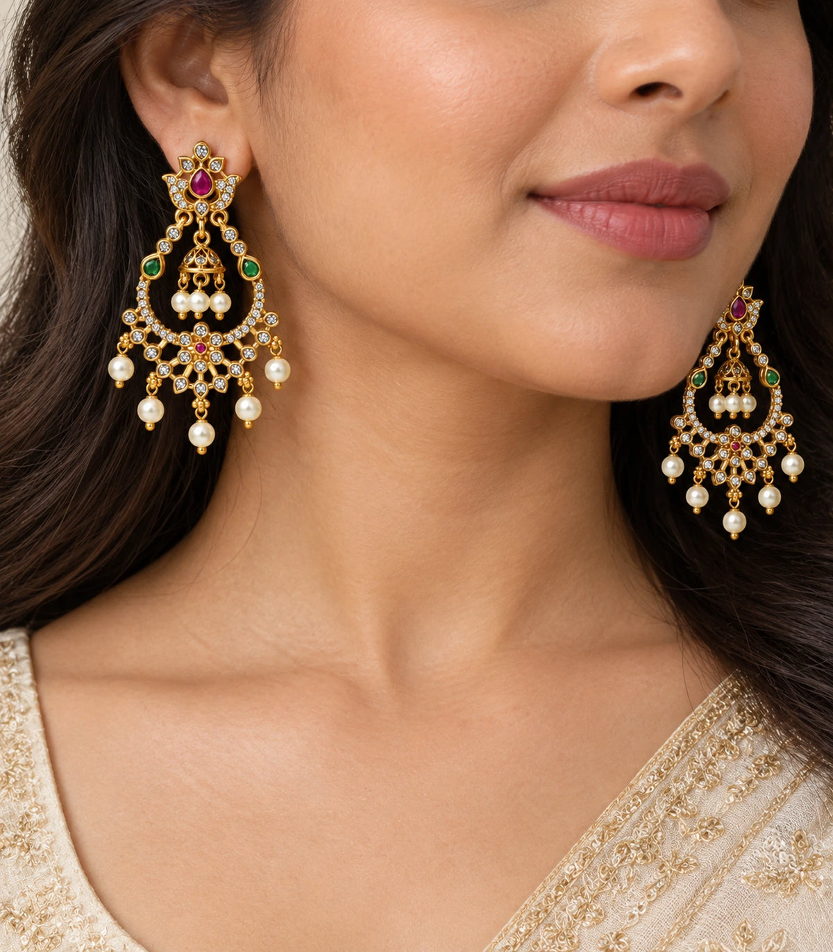 Close view of magenta and green chandbali earrings with central bell and pearl-style drops