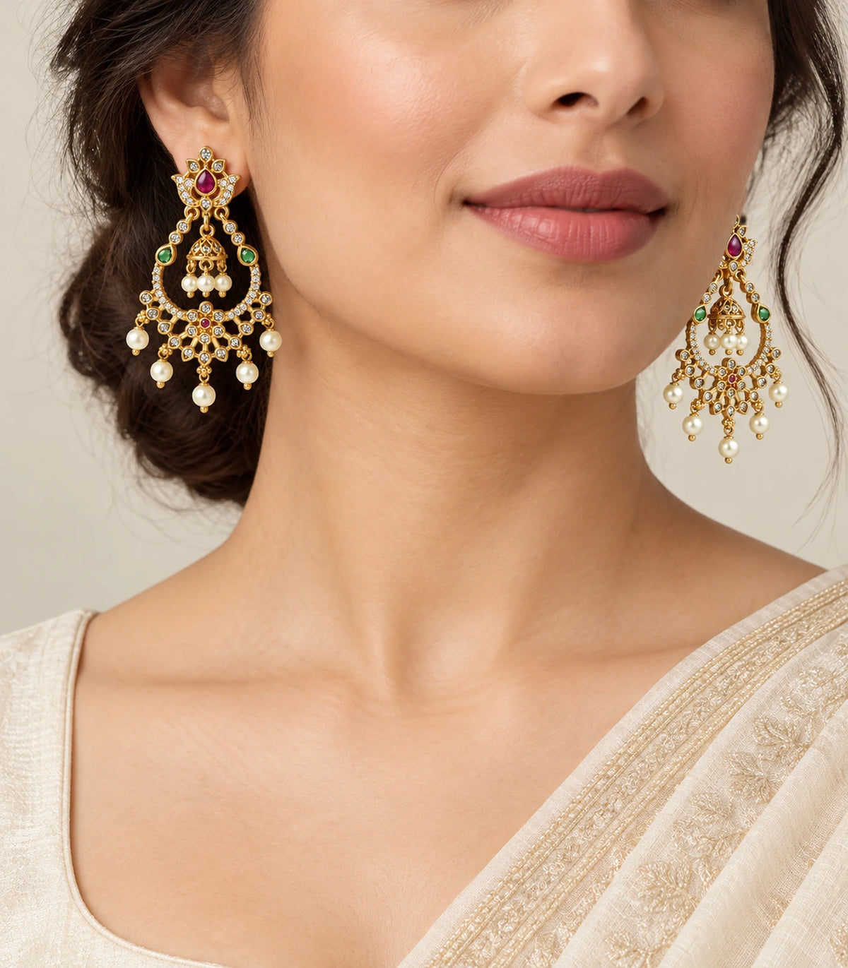 Gold-tone magenta and green bell-centre chandbali earrings worn with an ivory outfit