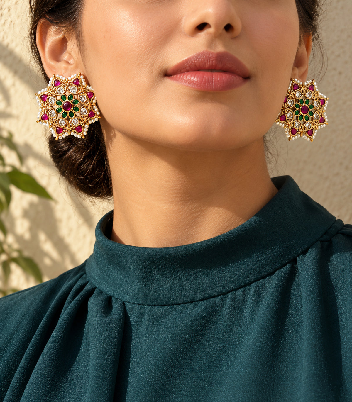 Gold magenta and green floral pearl border stud earrings in an editorial model view