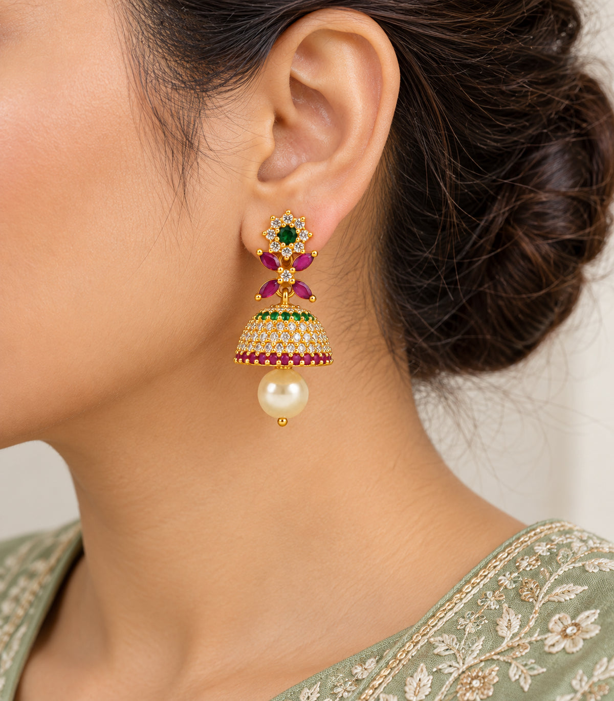 Close view of a gold multicolor floral earring worn at the ear