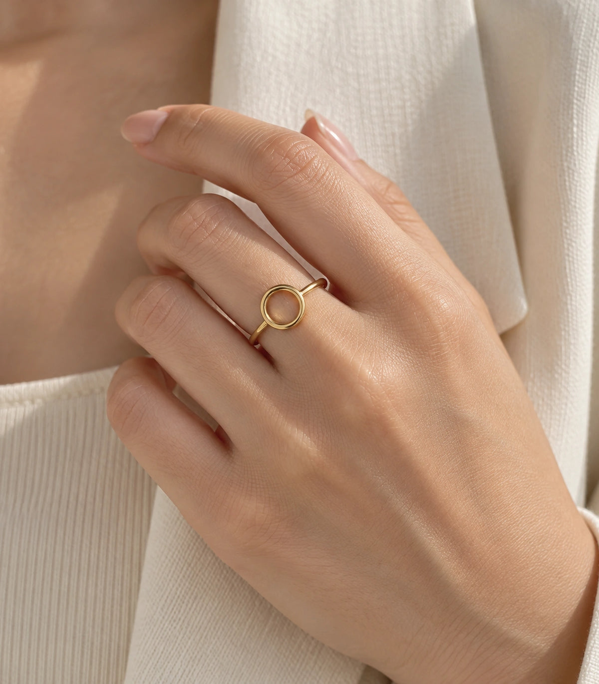 Gold Open Circle Minimal Ring worn in a distinct hand pose with cream clothing