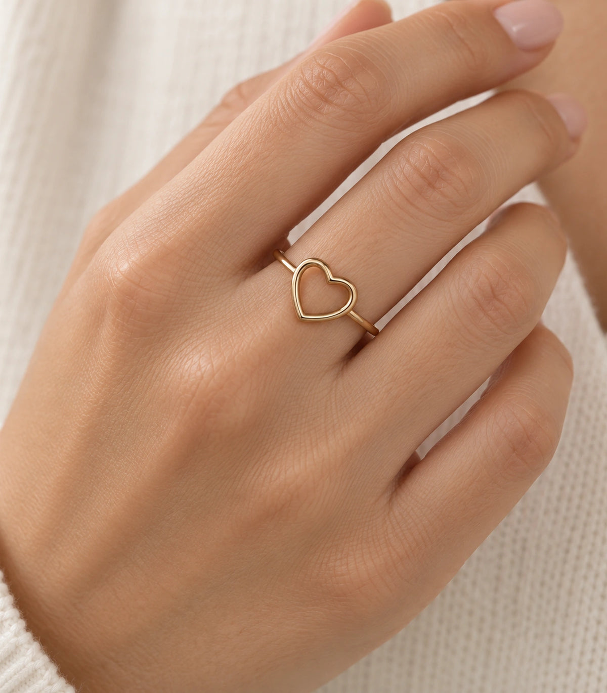 Gold open heart ring worn naturally on a finger