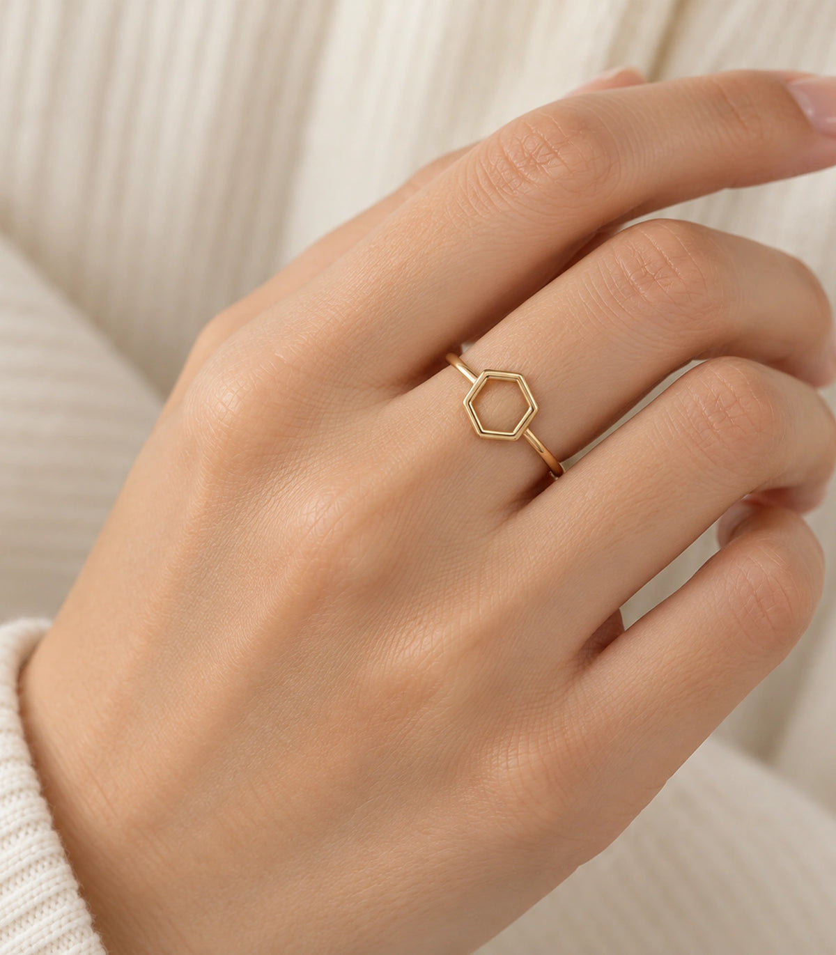 Gold Open Hexagon Minimal Ring worn on a finger against a cream sleeve