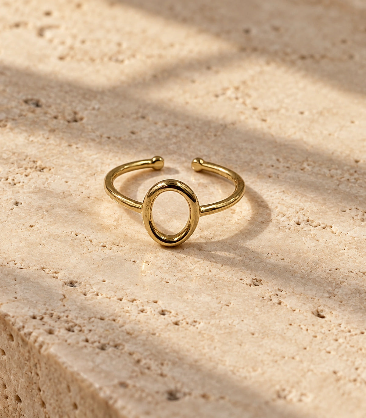 Gold Open Oval Minimal Ring on a stone surface