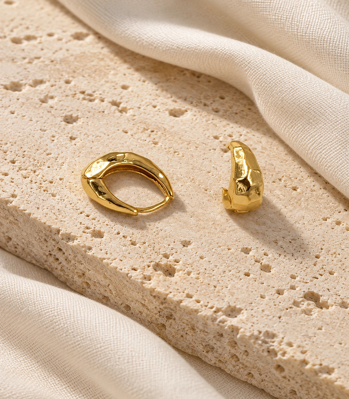 JIMIKI Gold Organic Hammered Huggie Earrings — editorial flat lay #color_gold-tone