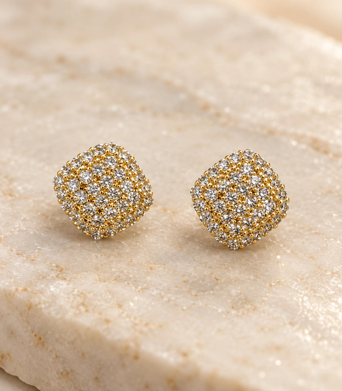 Gold-tone cushion cluster stud earrings, detailed pair on a stone surface