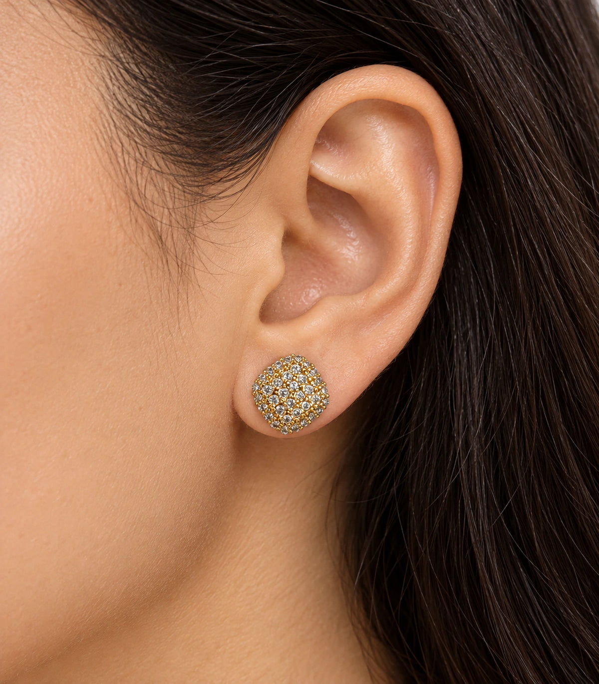 Gold-tone cushion cluster stud earring shown on an ear