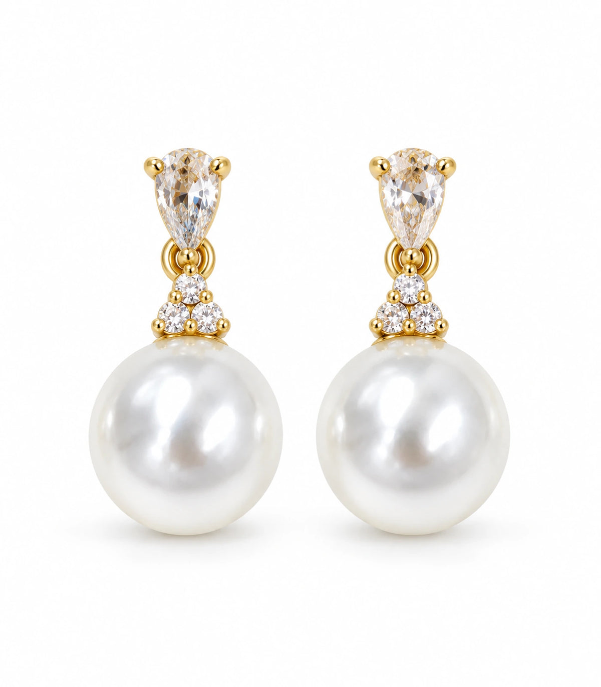 Matching pair of gold-tone drop earrings with pear-shaped clear crystal-style tops, three round accents and large white pearl-style drops on white.