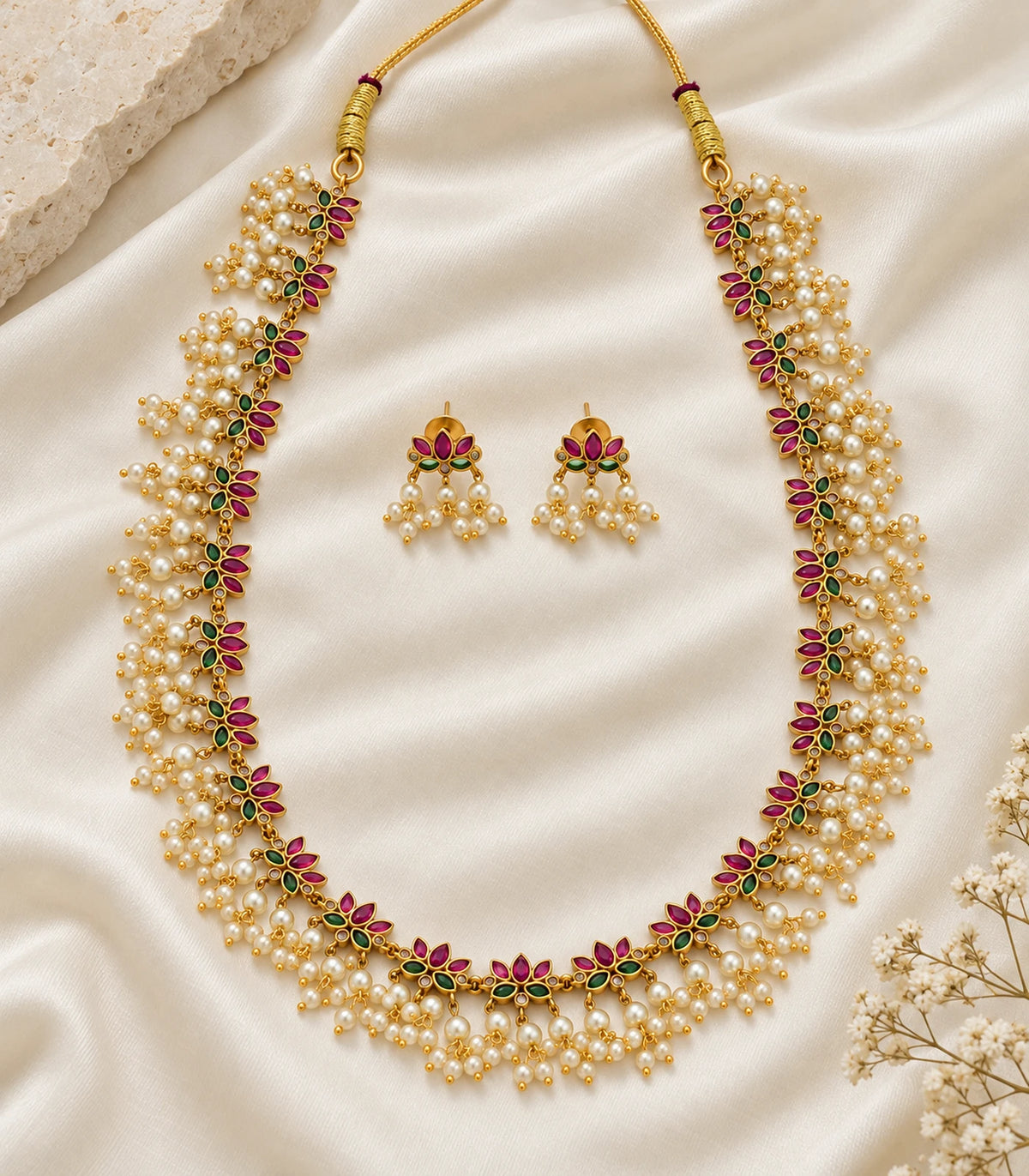 Gold Pearl Fringe Floral Necklace Set and matching earring pair on cream fabric