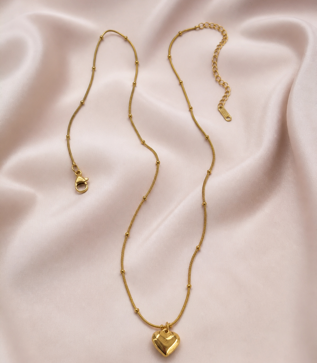 Gold Puffed Heart Bead Necklace styled in a flat lay