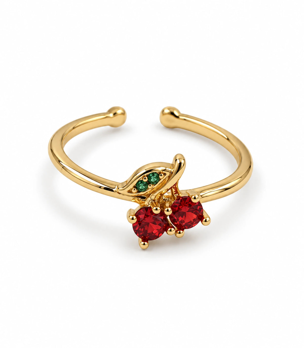 Gold-tone open ring with two red cherry stones and a green leaf on white