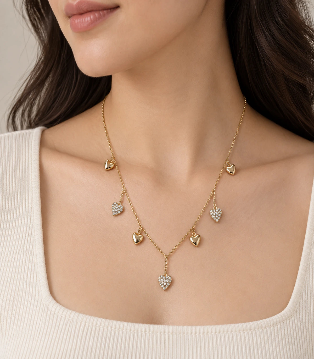 JIMIKI Gold Seven Heart Charm Necklace - heart charm necklace in an editorial worn view #color_gold
