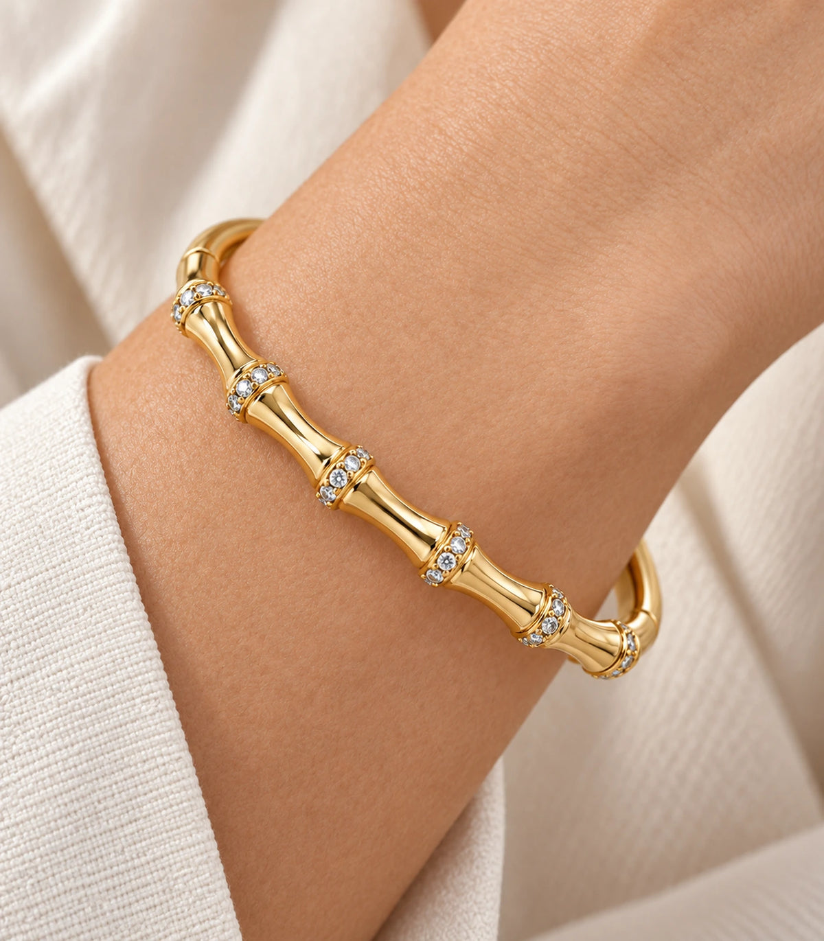 JIMIKI Gold-Tone Bamboo Pavé Collar Bangle — close-up of the bangle worn on the wrist #color_gold-tone / clear
