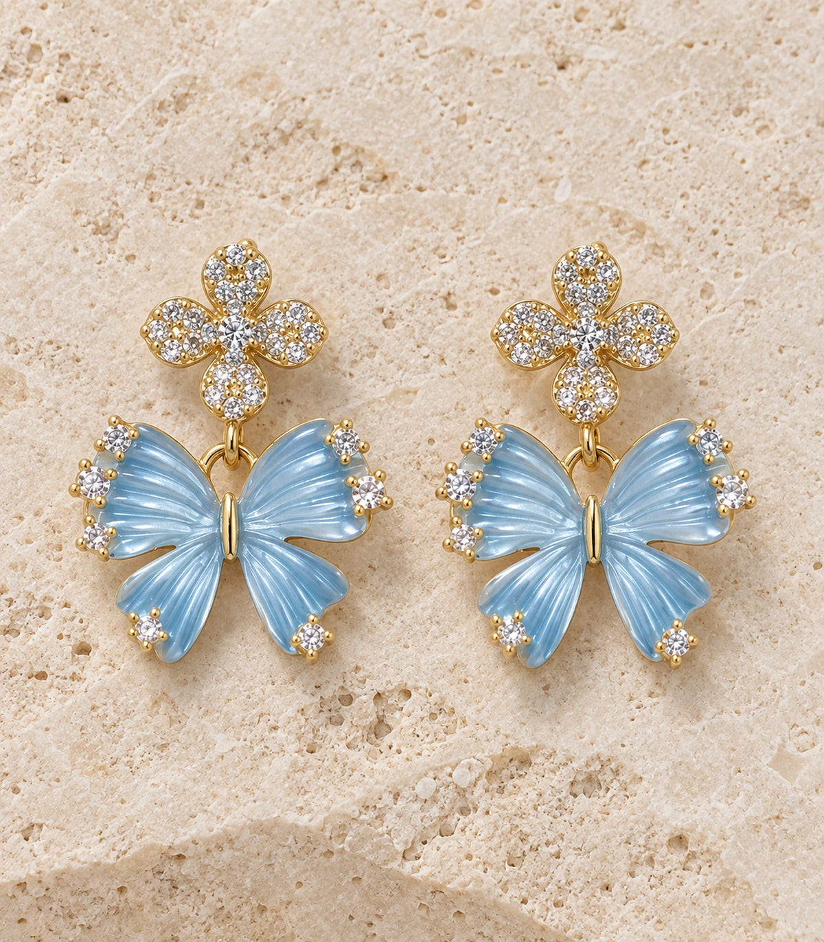 JIMIKI Butterfly Crystal Flower Drop Earring Pair in Gold tone / Blue, editorial flat lay #color_gold tone / blue