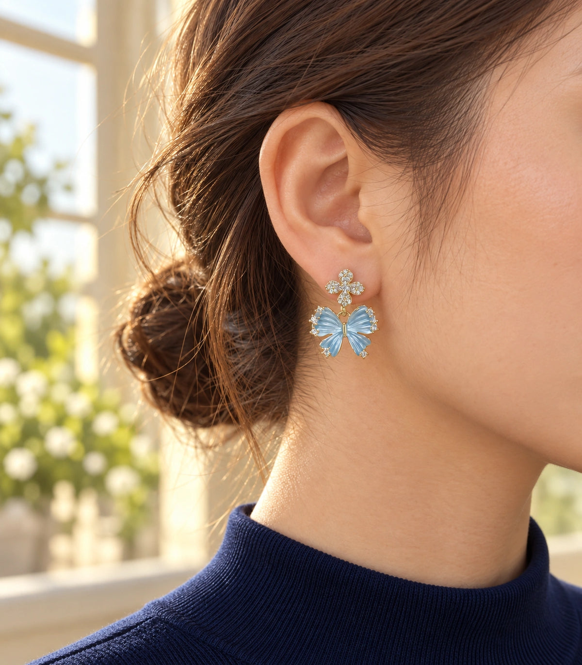 JIMIKI Butterfly Crystal Flower Drop Earring Pair in Gold tone / Blue, editorial model view #color_gold tone / blue