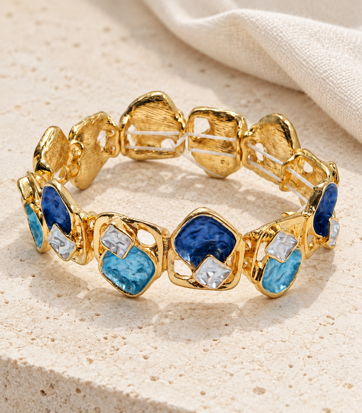 Gold-tone blue geometric openwork bracelet — editorial flatlay view
