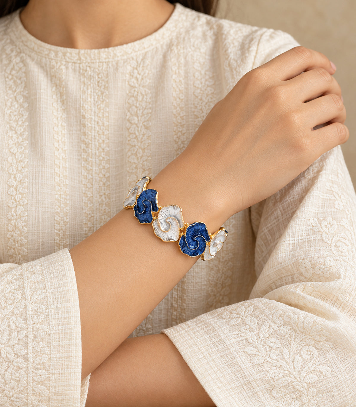 Gold-tone blue and white spiral-shell bracelet — editorial model view