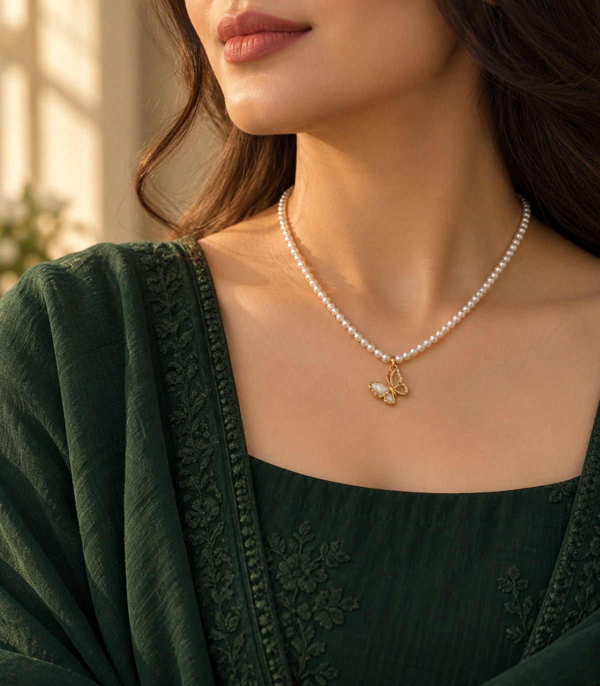JIMIKI Gold-Tone Butterfly Pearl Necklace in Gold-tone / white, styled on a model in an editorial setting