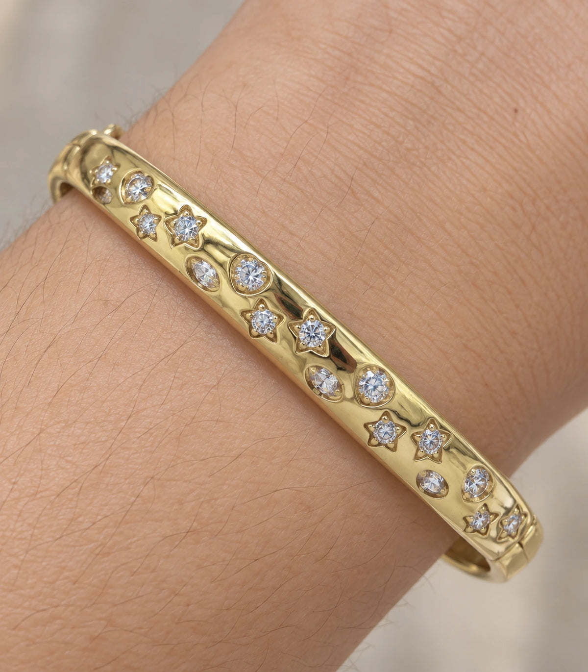 JIMIKI Gold-Tone Celestial Crystal Bangle — close-up of the bangle worn on the wrist #color_gold-tone / clear