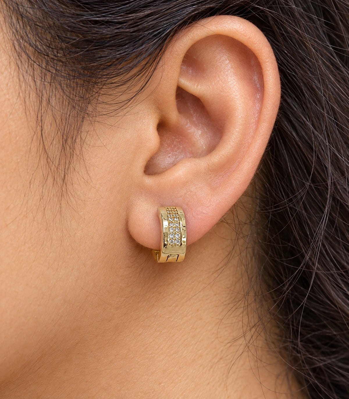 JIMIKI Gold Tone central pave strip huggie hoop earrings, worn closeup of clear central pave strip #color_gold-tone