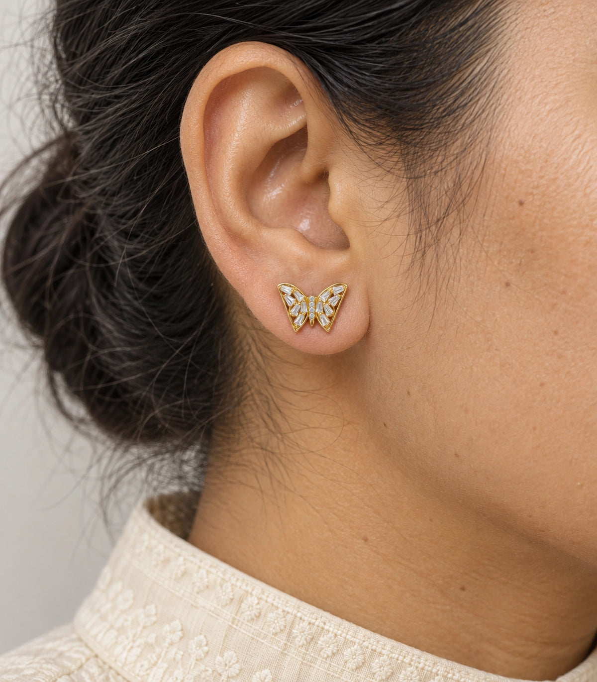 JIMIKI Gold Tone Clear Baguette Butterfly Stud Earring Pair in Gold tone, close-up detail